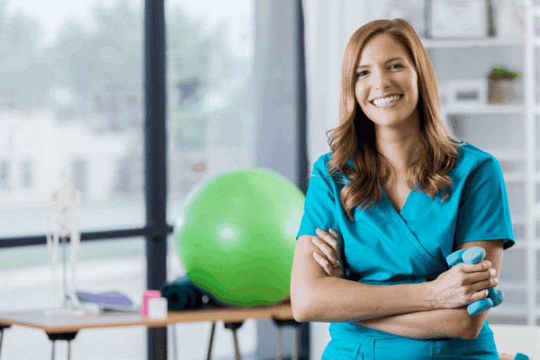 Woman in scrubs working a travel contract in a physical therapy clinic